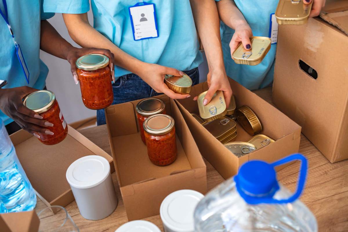 Cardboard boxes being filled with food donations.