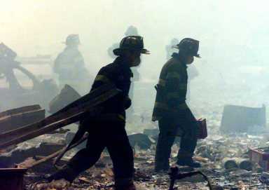 FIREFIGHTERS WALK AMID RUBBLE AT WORLD TRADE CENTER.