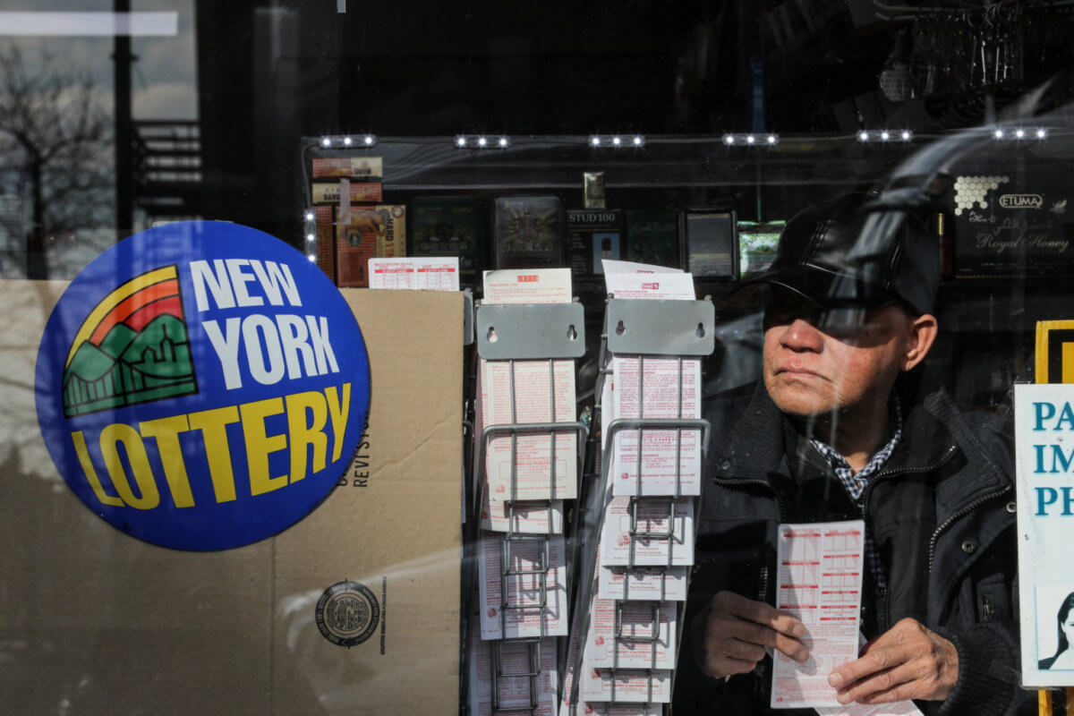 A customer holds a ticket at a storefront in the Queens Borough of New York