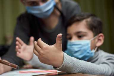 Distance education. Mother helps a pre-school kid to do lessons