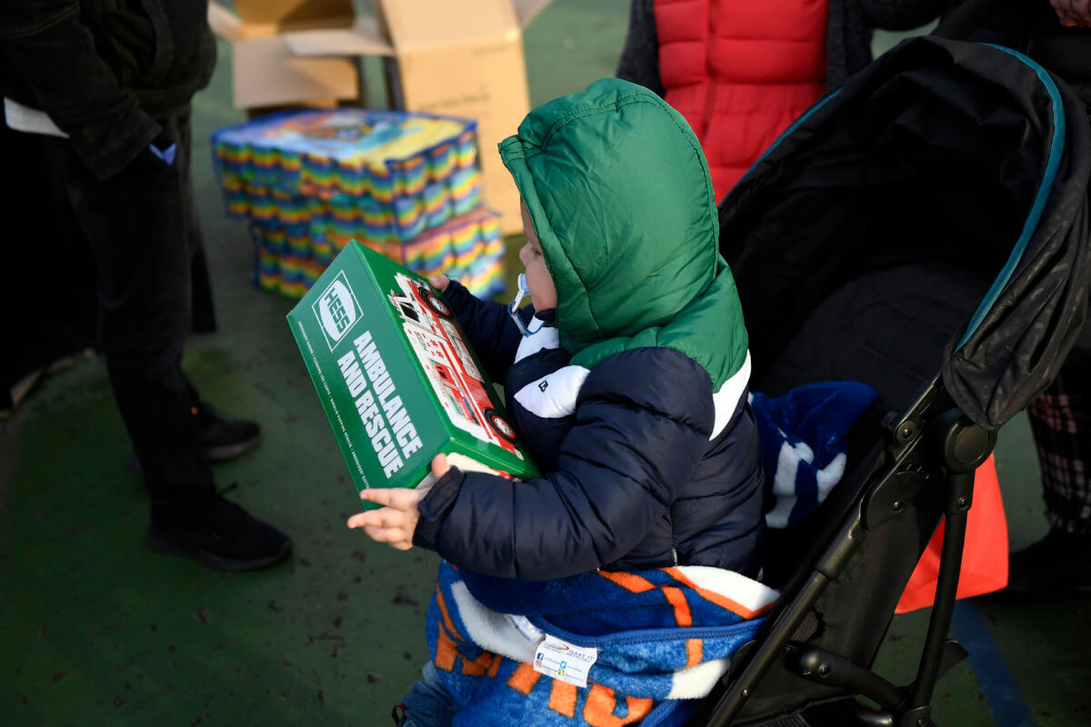 A little boy holds a Hess Truck he received at the toy giveaway. The First Responders Children's Foundation, with the FDNY and NYPD, hosted the FDNY EMT Yadira Arroyo Memorial Toy Giveaway in the Bronx on Wednesday, Dec. 23, 2020.