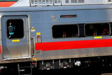 A man wearing a protective face mask, as the global outbreak of the coronavirus disease (COVID-19) continues, boards a train at the Metro-North Railroad and Amtrak train station in New Rochelle, New York