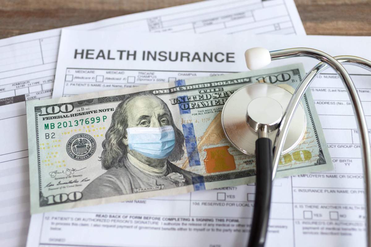 One hundred us dollar with face mask on insurance paper bill. Health care cost during coronavirus covid outbreak concept