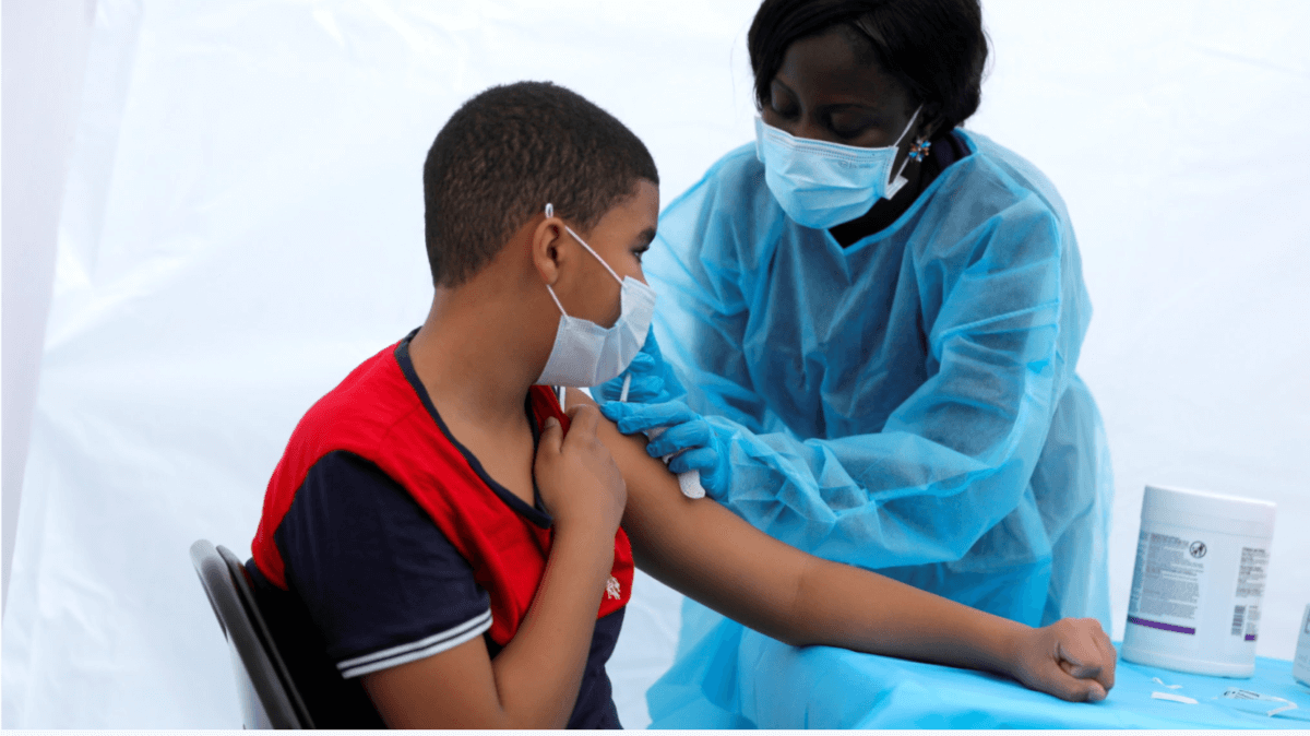 A nurse administers the COVID-19 vaccine to a 12-year-old child outside the Bronx Writing Academy school on June 4.