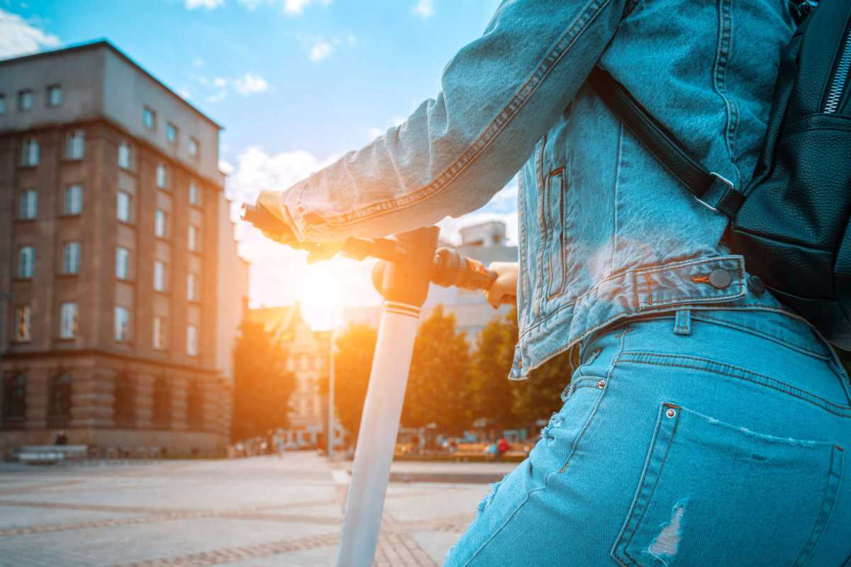 Scooter nature. Kick electric city bike using from business woman. Electric scooters for public share standing outside.