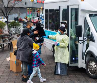 Bronx residents visit a mobile COVID testing site in the Fordham section of the Bronx.