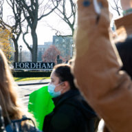 a Fordham sign behind protestors