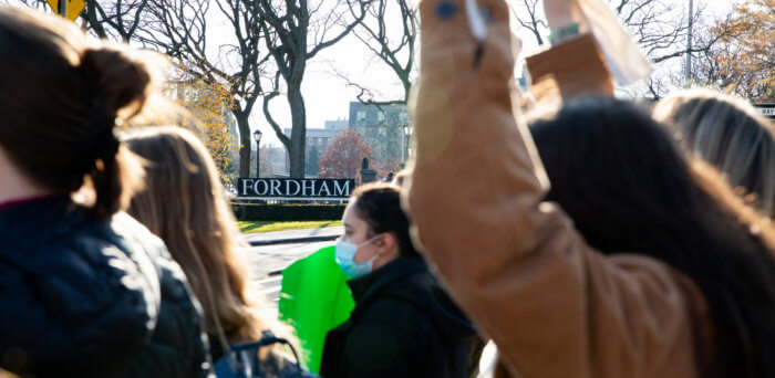 a Fordham sign behind protestors