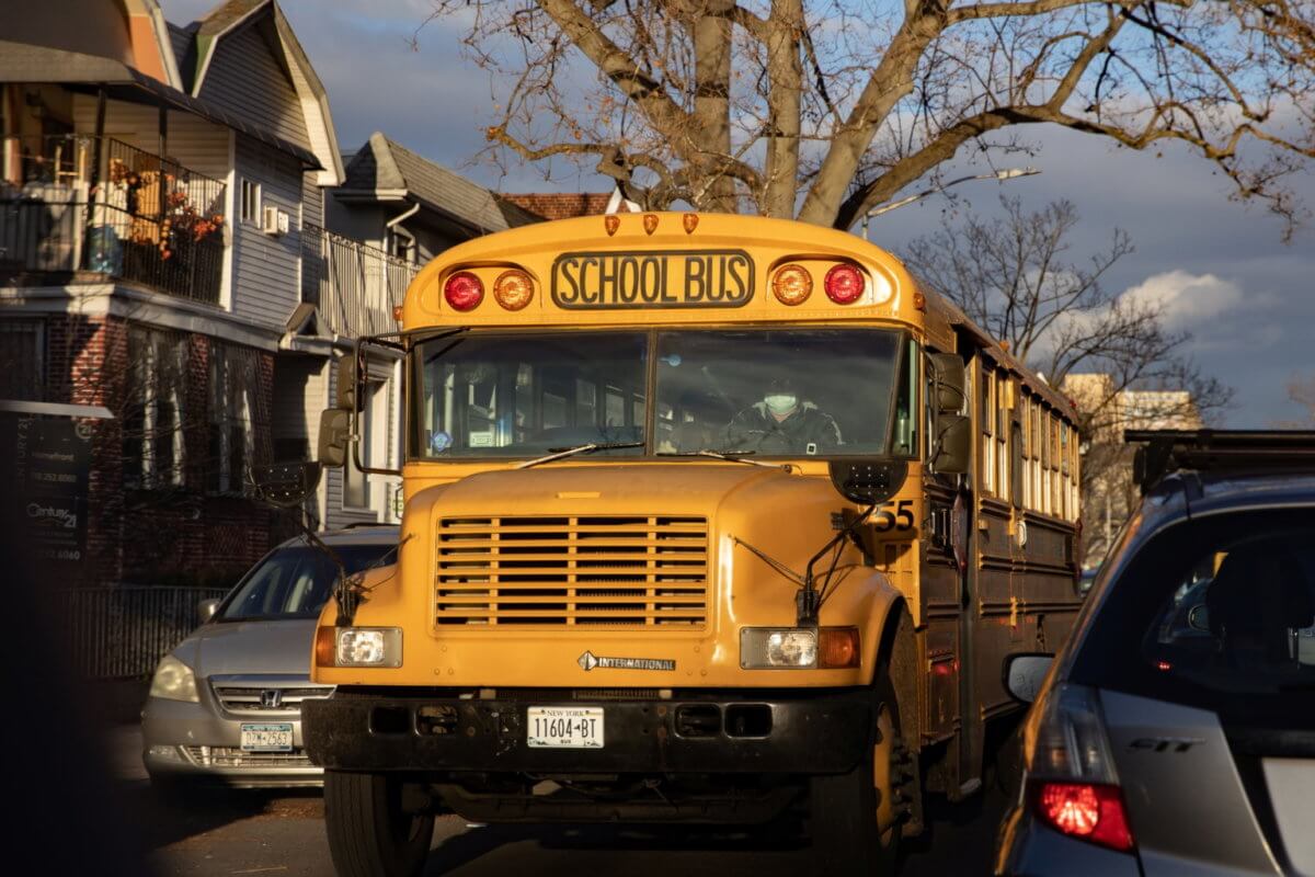 A driver wearing a protective mask drives a school bus during the COVID-19 pandemic in the Brooklyn borough of New York City