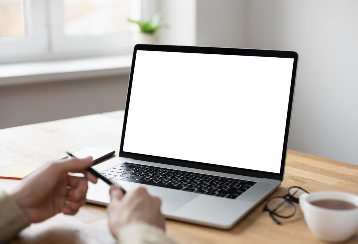 Man using laptop computer, white blank empty screen monitor
