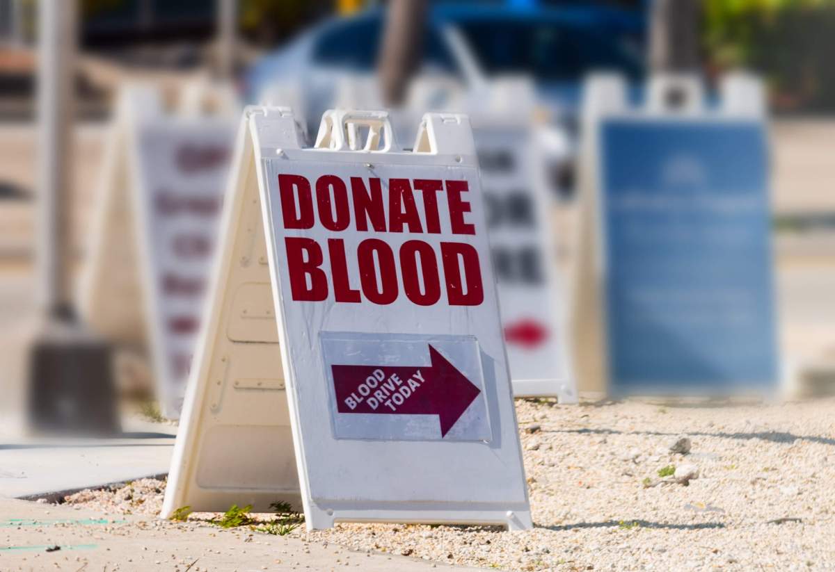 Donate Blood written on a sandwich board sign