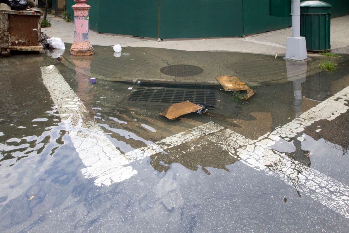 Sewage drain clogged causing flood on street corner Bronx NY