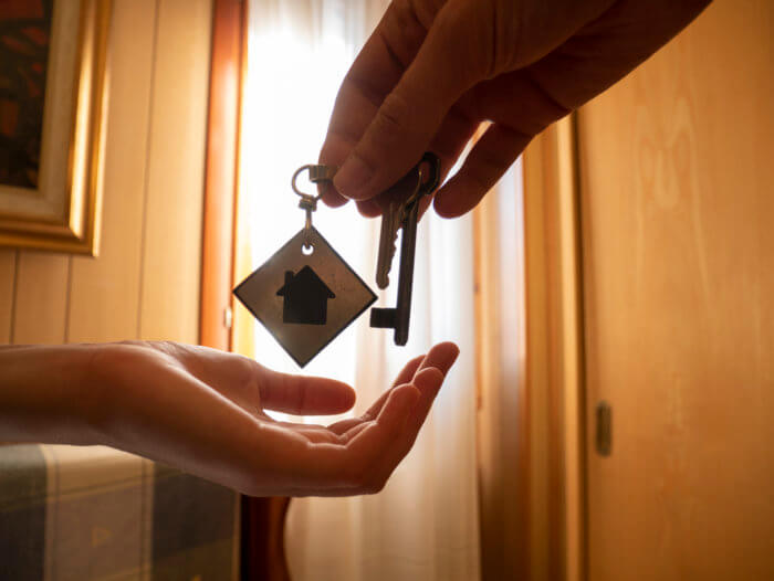 Hands give the keys to a room, the customer receives the keys to a holiday home keys in hand
