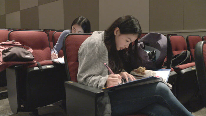 A still from HBO's film "My So-Called College Rank," which features students from the Bronx, shows kids doing homework in between takes.