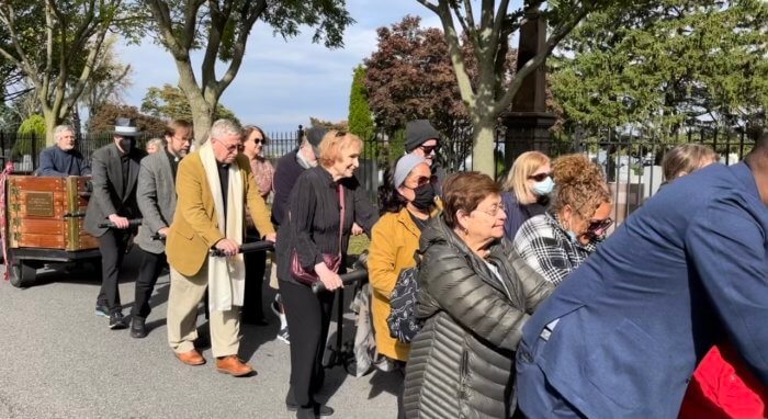 Advocates for the Hart Island touchstone project march the stone to the Hart Island Ferry Terminal on City Island in October 2022.