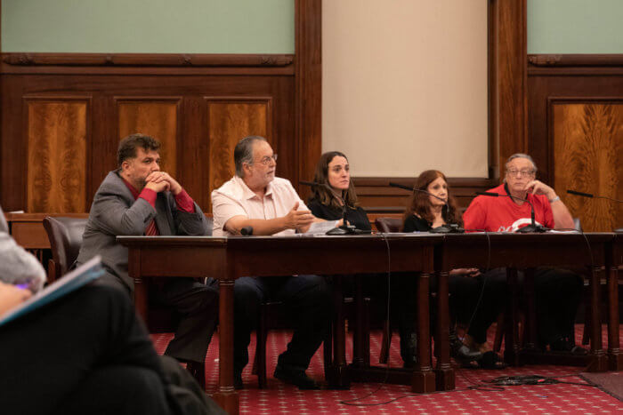 five people sitting at table in City Council chamber