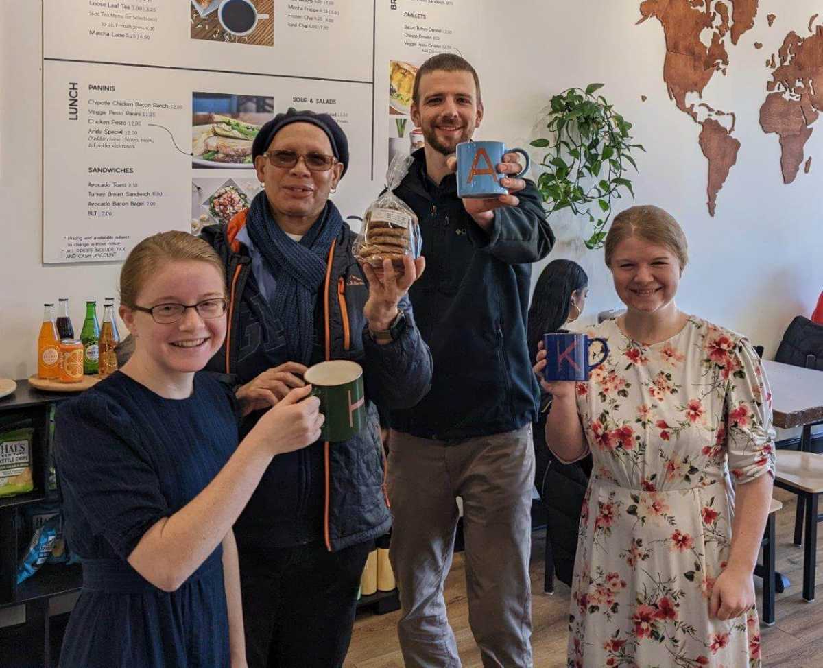 four people pose in cafe