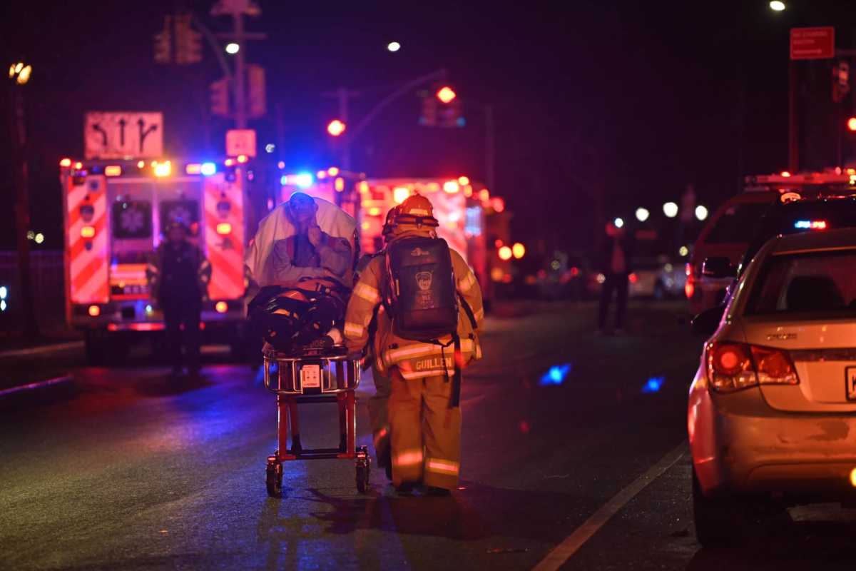 A first responder treats a patient after a five-alarm fire at the C-Town Supermarket in Morris Heights on Thursday, Feb. 9, 2023.