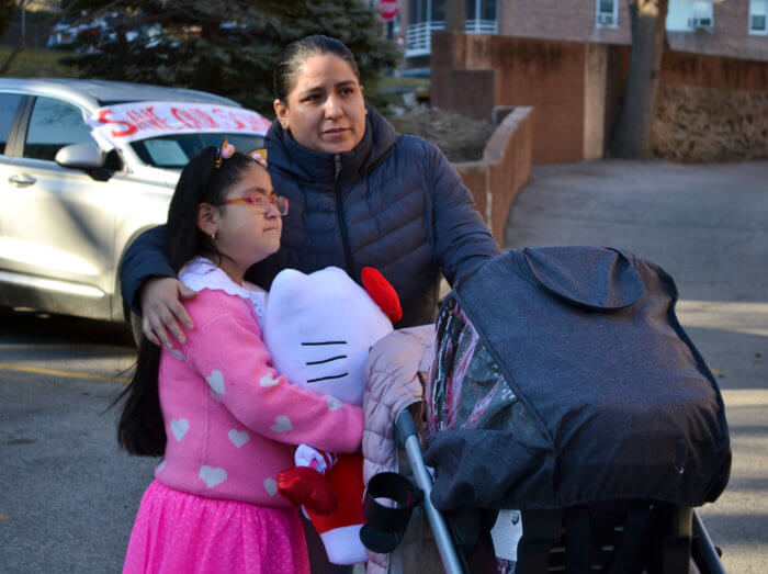 Emily Delgado, left, a second grader, is comforted by her mother, Veronica Carpio, in St. Gabriel’s School Parking Lot as they listen to speakers at the rally on Tuesday, Feb. 14, 2023. Carpio said the school community is friendly and rumors of the closure came as a surprise to some parents. She also said her daughter is very sad and they don’t know where to go next for her education.