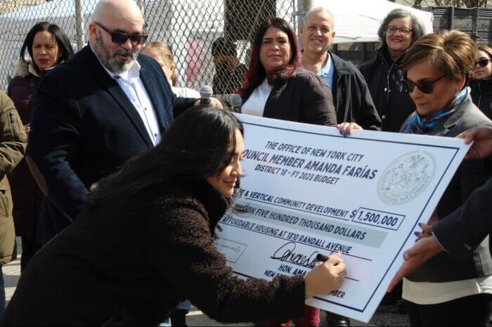 Amanda Farías signing a big check