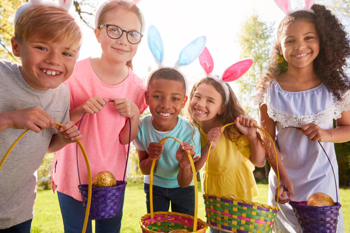 Kids wearing bunny ears and holding baskets on an Easter egg hunt