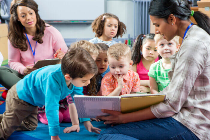 Adult reading a story to a group of children.