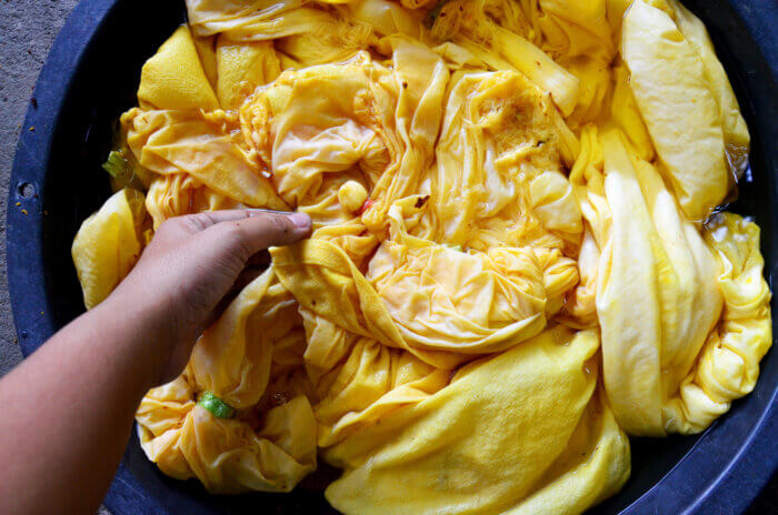 Bowl of clothes dyed yellow.