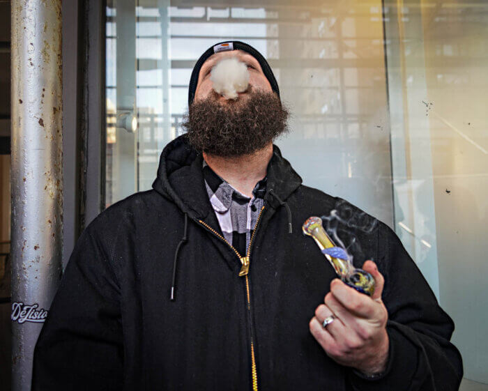 Ken Woodin smokes a bowl at the opening of the city's first legal recreational dispensary in the East Village on Thursday, Dec. 29, 2022. 