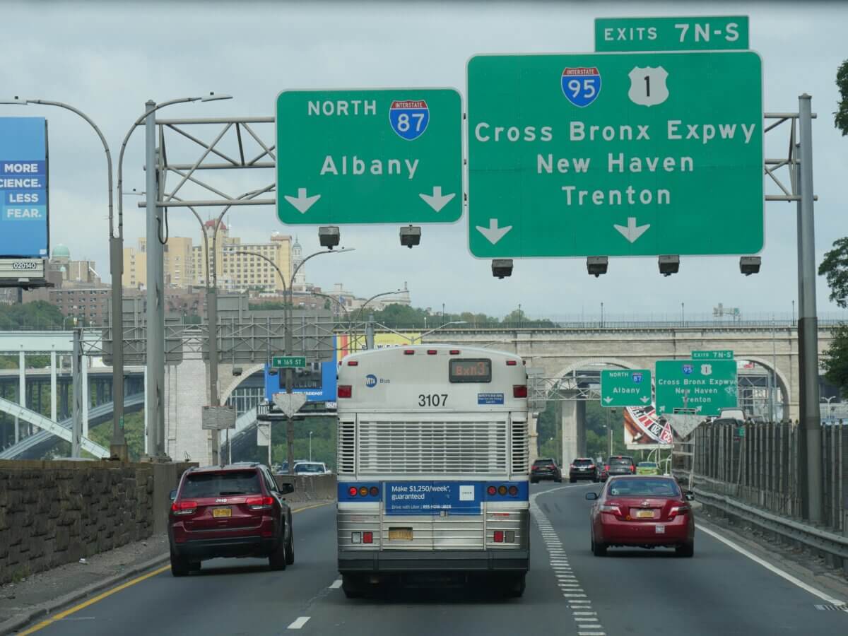 Close up of directional signs on the road with arrows to Albany, Cross Bronx Expressway, New Haven and Trenton.