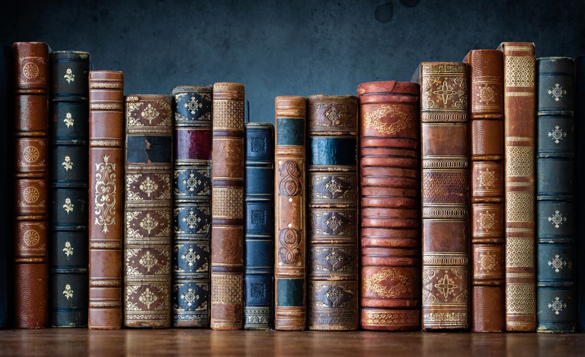 Old books on wooden shelf. Tiled Bookshelf background.  Concept on the theme of history, nostalgia, old age. Retro style. The book is a symbol of knowledge.