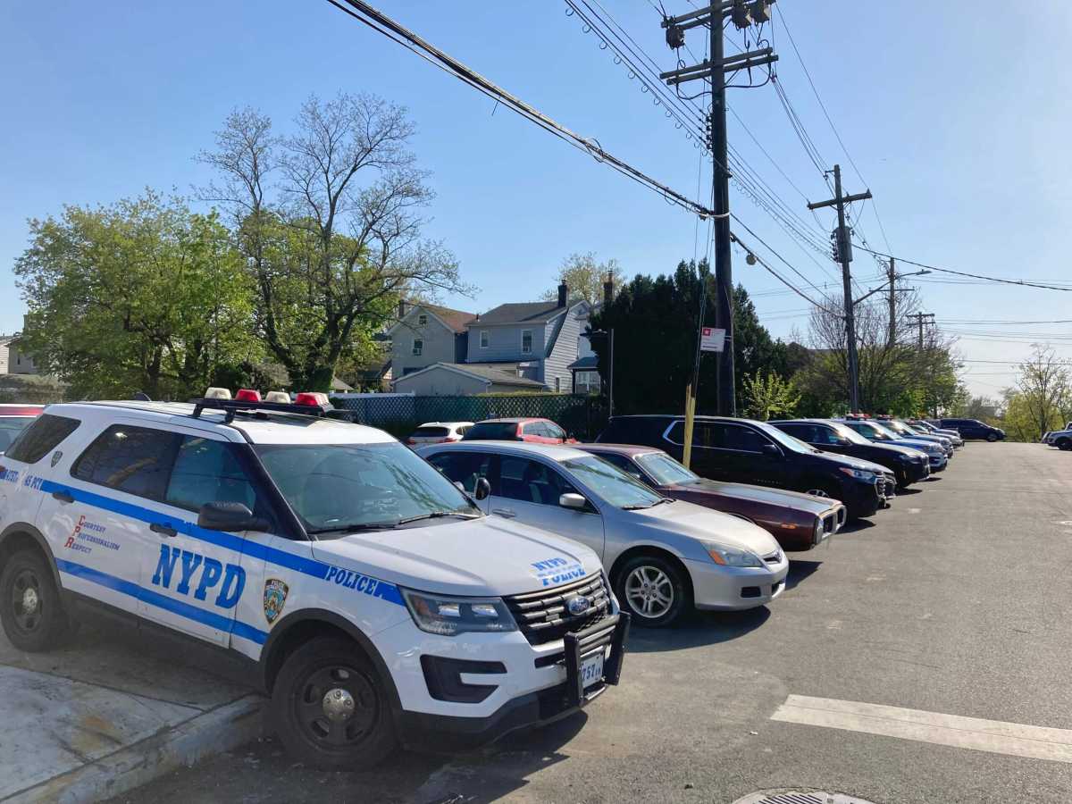 Vehicles line the sidewalk surrounding a sign that says Authorized Vehicles Only Police Department