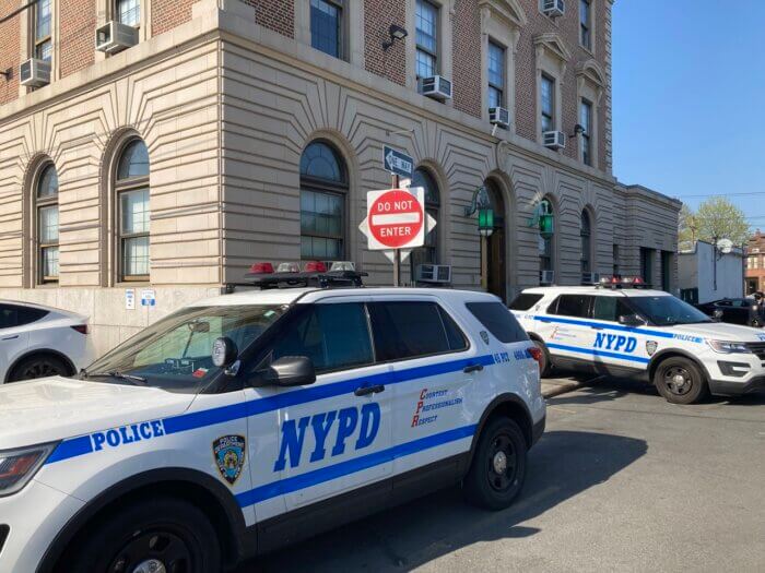 NYPD cars in front of precinct including on the sidewalk