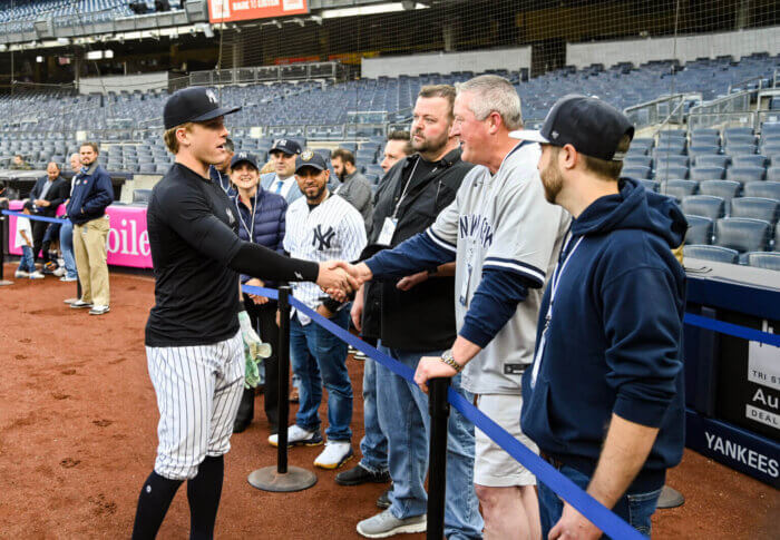 MTA employees dressed in Yankees gear shake hands with center fielder Harrison Bader.
