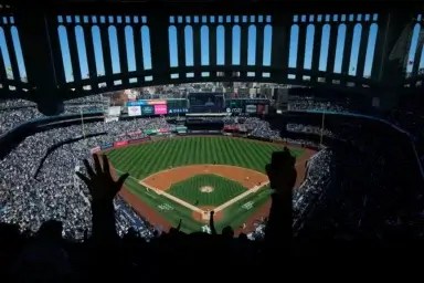 A fan's hands are in the air, cheering at the Yankees game.