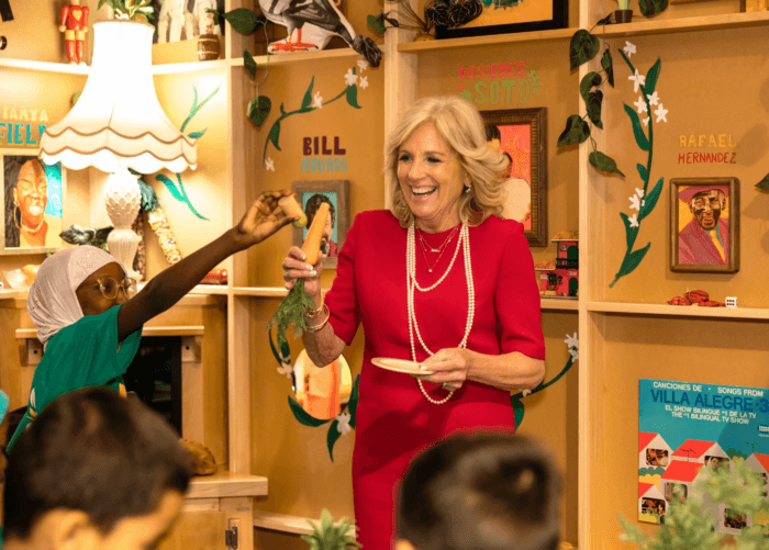 A student from PS 55 seasons a toy carrot for the First Lady as they play in the Casita