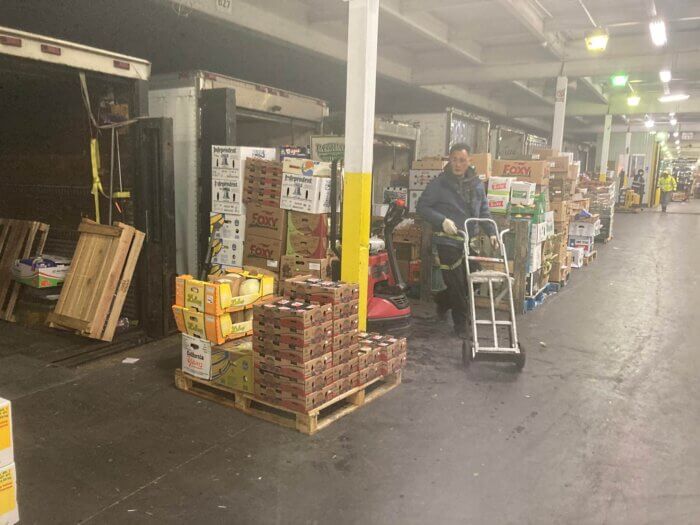 worker pushes a cart in the produce market