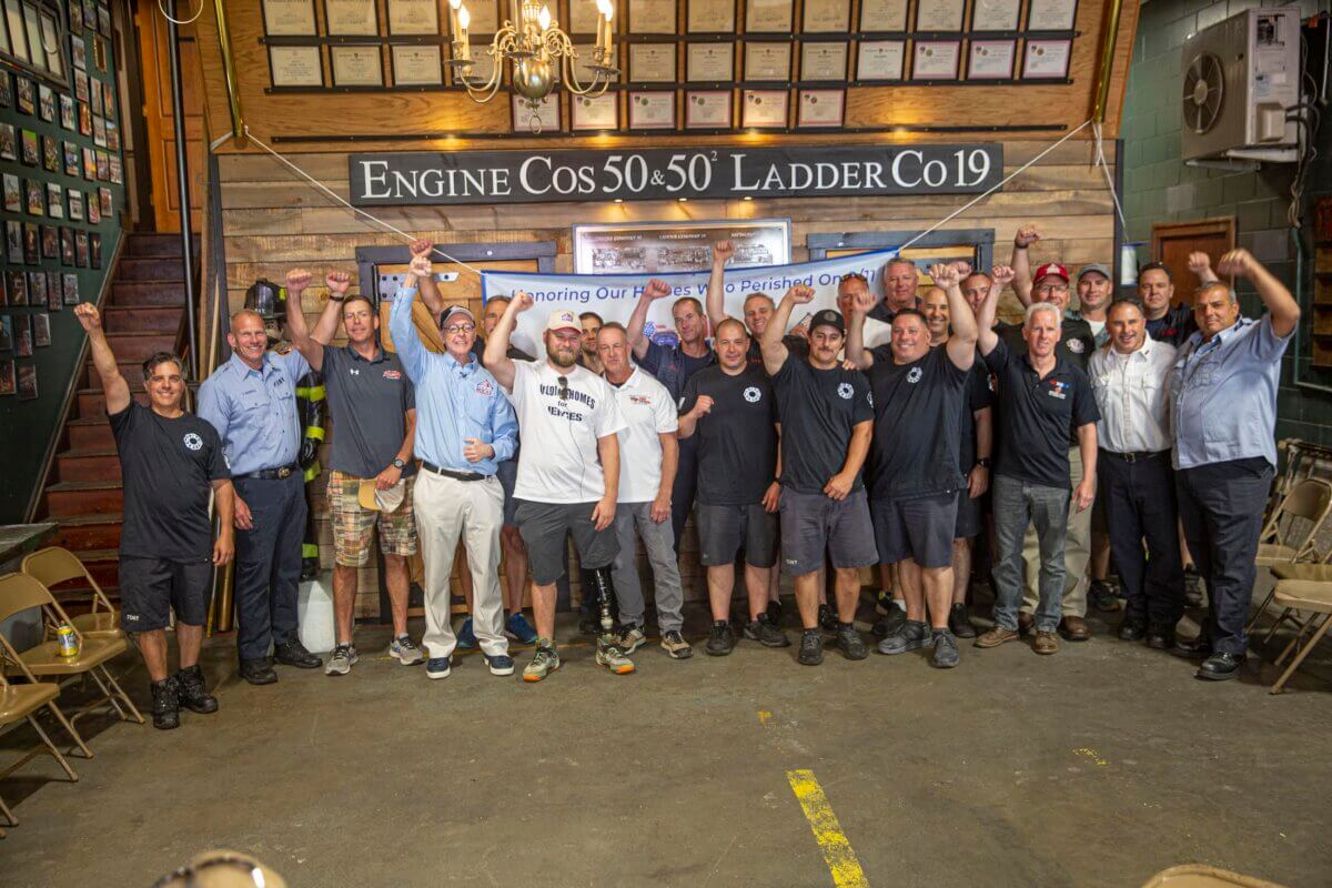 Evan Marcy was awarded his home at the Engine 50, Ladder 19 station where his father worked. Marcy is pictured center left with Building Homes for Heroes Founder and CEO Andy Pujols on his left and retired FDNY Captain Mike Alexander on his right.