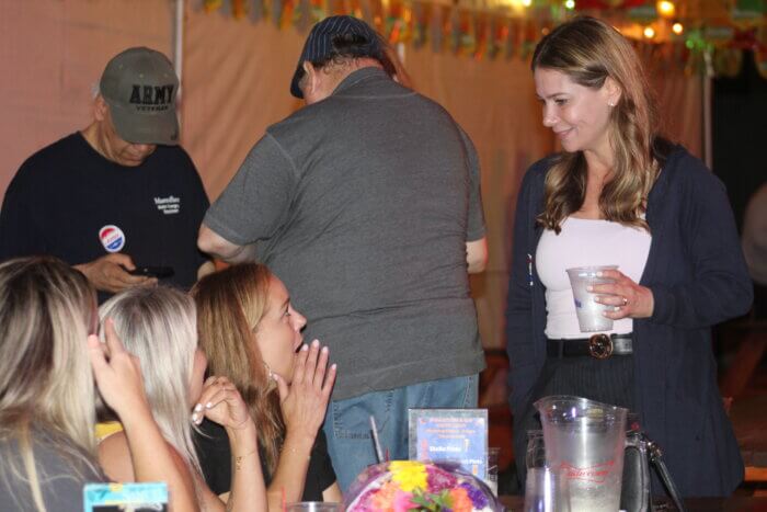 Kristy Marmorato looks at three supporters while holding a drink