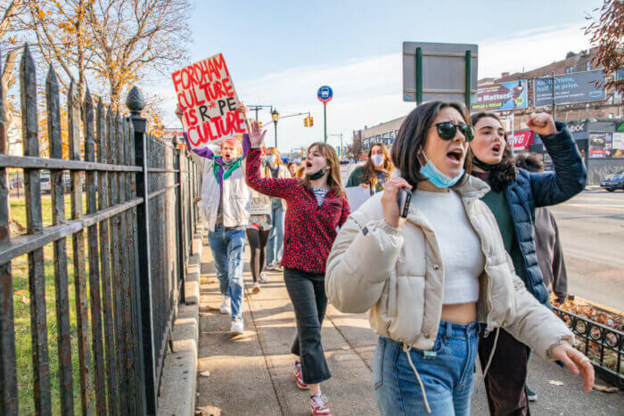 people yelling and walking, a sign reads "Fordham Culture is r*pe culture"