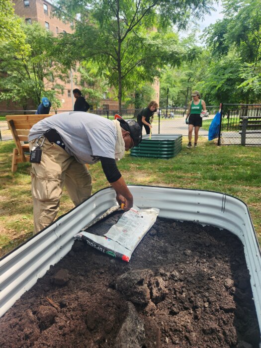 a person puts soil in a planting bucket