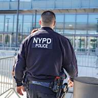 NYPD Neighborhood Safety Teams officers wear black uniforms with white lettering and drive unmarked cars. They are responsible for engaging with residents in an effort to combat gun violence. Photo Dean Moses