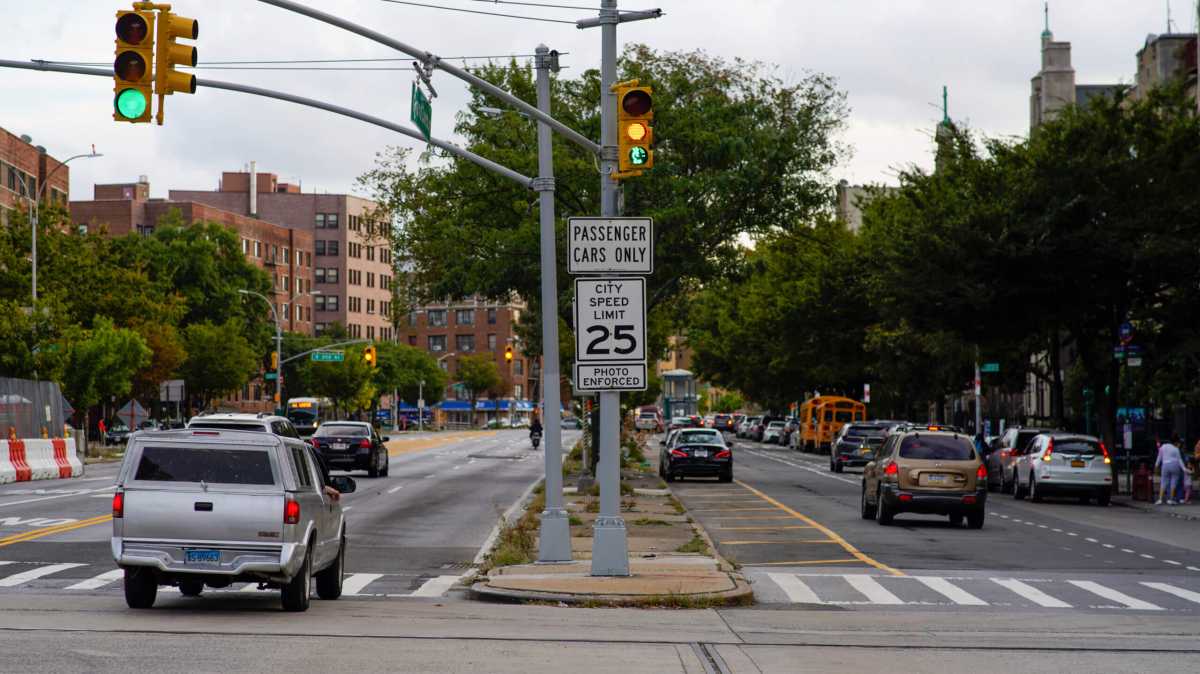 sign shows speed limit and warns of traffic camera enforcement in between traffic