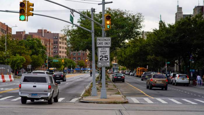 sign shows speed limit and warns of traffic camera enforcement in between traffic