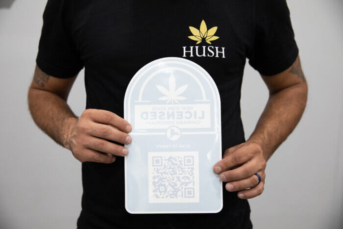 close up of a sticker with a QR code and marijuana leaf in Denis Ozkurt's hands