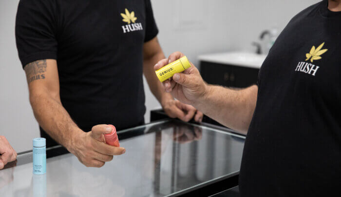 Hand holds a yellow canister that says "genius, 30 plant-based pills for brain power"