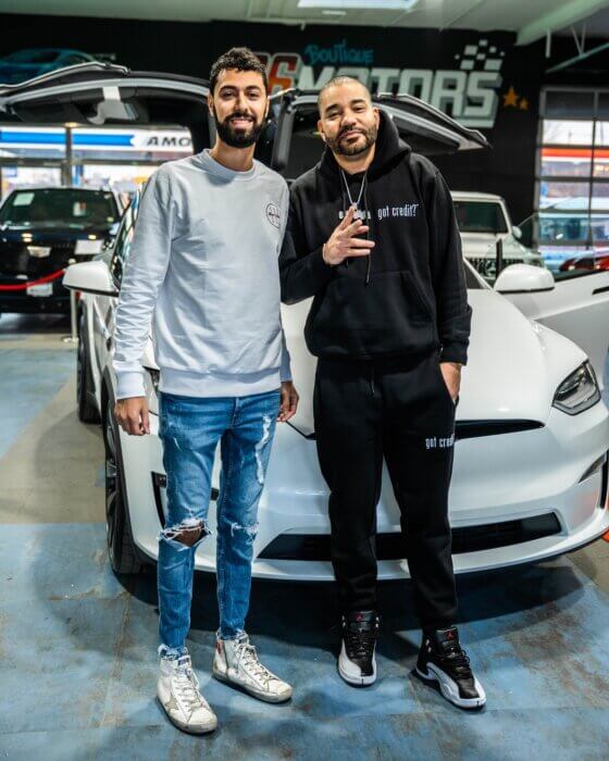Moshe Pourad is pictured at his luxury car business 26 Motors with DJ Envy of Power105.1.