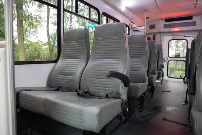 the interior of the bus, showing grey cushioned seats