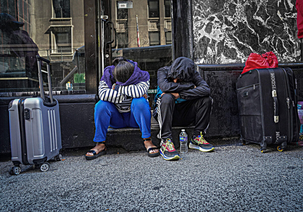 two people sit on steps with their heads in their arms