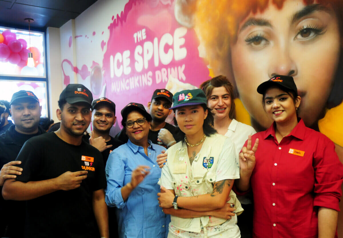Muralist Kamille "OG Millie" Ejerta poses with Dunkin' Donuts staff after painting a mural celebrating a new collaboration with Bronx-born rapper Ice Spice on Wednesday, Sept. 20, 2023.