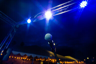 Comedy or Live Music Show at Night Outdoors with Microphone and Blue Lights Nightlife
